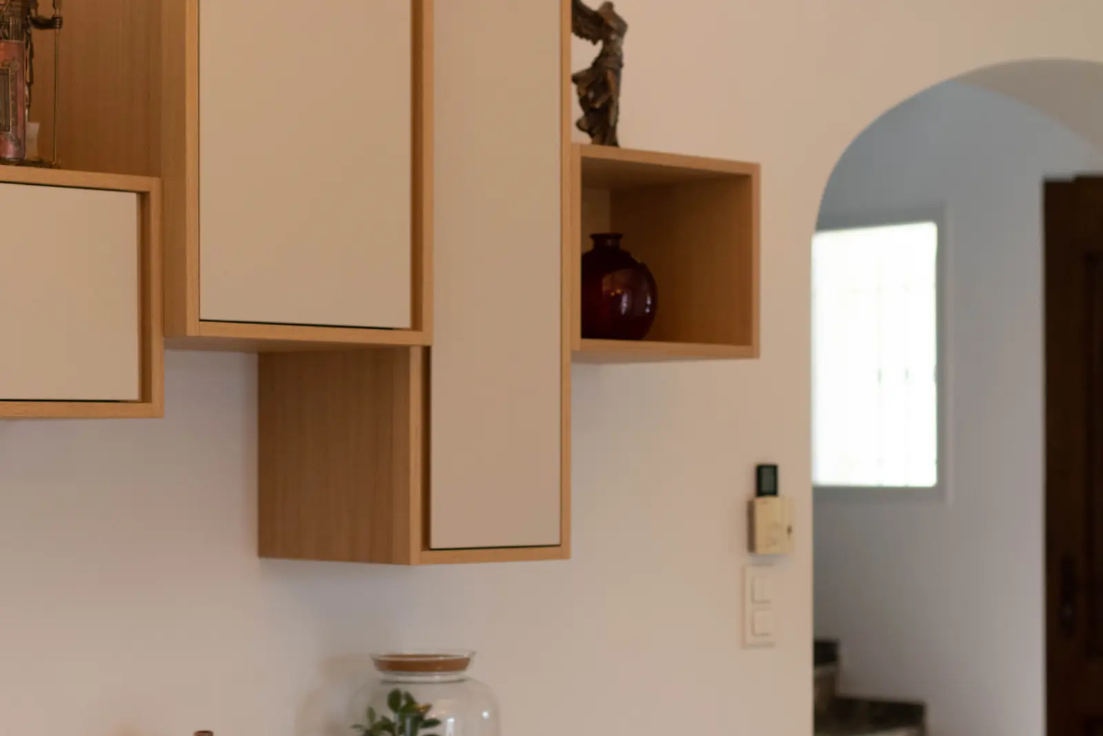 Rangements muraux sur mesure en chêne clair et façades blanches, niches ouvertes et caissons suspendus fabriqués par un artisan menuisier près de Marseille
