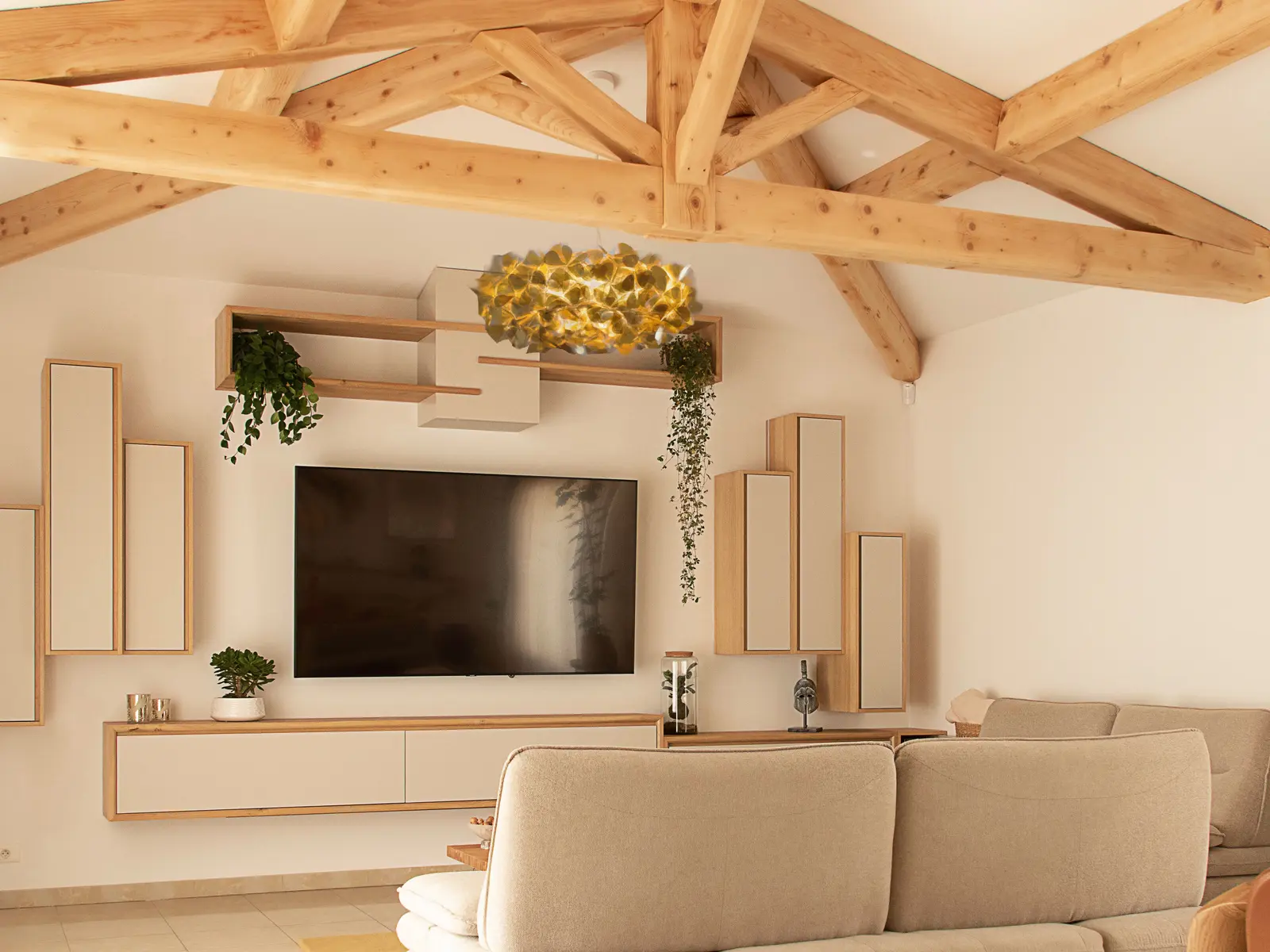 Salon avec meuble TV suspendu et rangements sur mesure en chêne clair sous charpente apparente, réalisation à Gignac-la-Nerthe près de Marseille